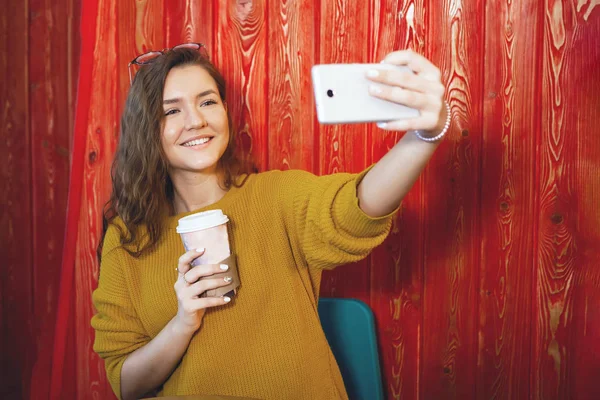 Portrait of beautiful young woman with phone in cafe. — Stock Photo, Image