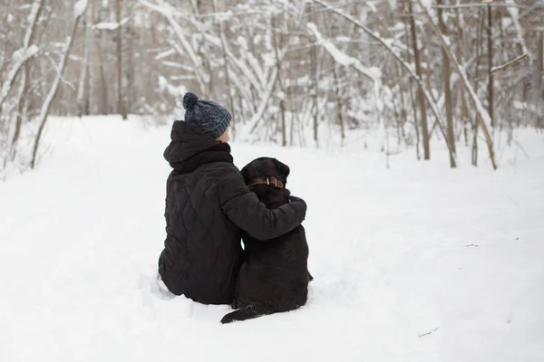 Chłopiec nastolatek z psem czarny Labrador Retriever. — Zdjęcie stockowe