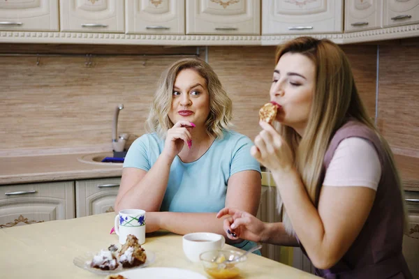 Две девушки женщины на кухне веселятся и едят еду . — стоковое фото
