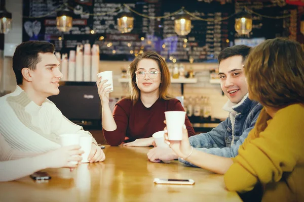 Четыре молодых хороших студента, сидящих в кафе . — стоковое фото