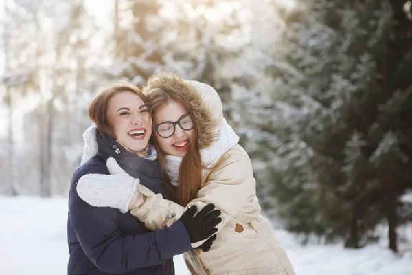 Duas jovens e bonitas mulheres numa floresta nevada . — Fotografia de Stock
