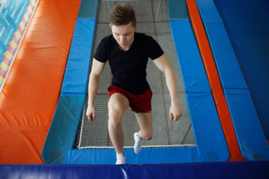 Bir trambolin üzerinde atlama genç adam.