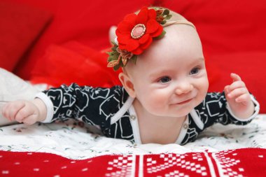 Kırmızı bir arka plan üzerinde mavi bir elbise güzel beş aylık bebek kız.