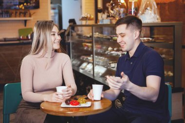 Bir kafede iki sevimli genç erkek ve kız.