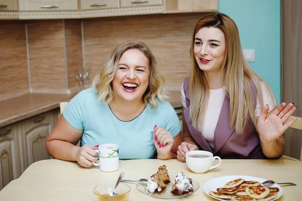 Dos novias mujeres en la cocina se están divirtiendo y comiendo comida . — Foto de Stock