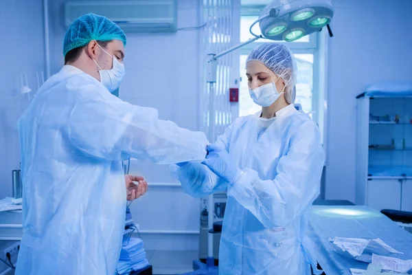 Asistente médico ayuda a un cirujano . —  Fotos de Stock