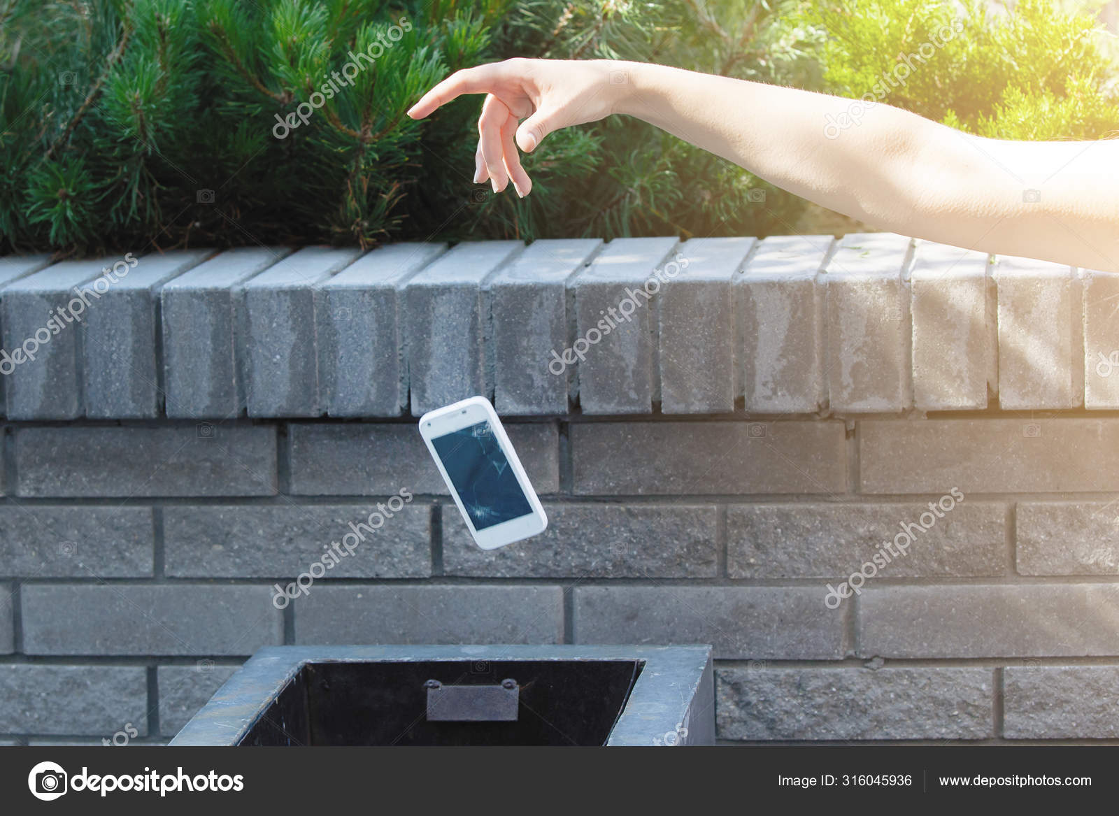 Man throwing phone in garbage bin Stock Photo by ©vorobevaola 316045936