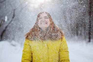 Genç, güzel, neşeli kızıl uzun saçlı kadın kışın dışarıda.