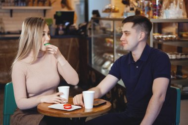 İki sevimli genç öğrenciler - erkek ve kız, bir kafede oturup.