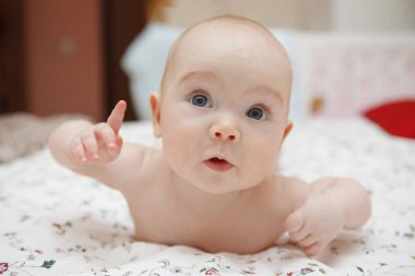 Midesini yüzünde çeşitli duygular yatan güzel beş aylık mavi gözlü bebek kız bebek. Bebek bak. Anne bakım. Çocuk Bakımı. Yakın çekim.