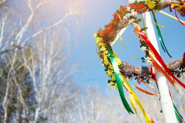 Mavi arka planda parlak kurdeleli ahşap tekerlek. Slav 
