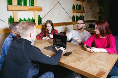 Bir bardaki masada oturan bir grup genç.