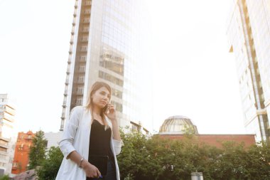 Park çimenlerin üzerinde oturan kadın.