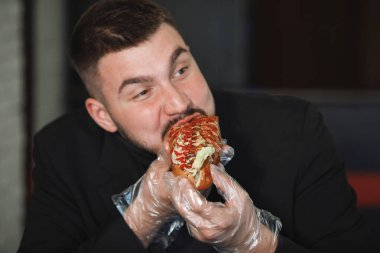 Adam hamburger yiyor.
