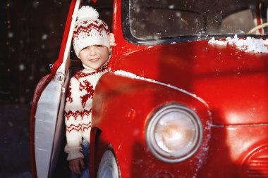 Kırmızı bir retro arabanın yanında iki çocuk. Noel, Yeni Yıl konsepti.