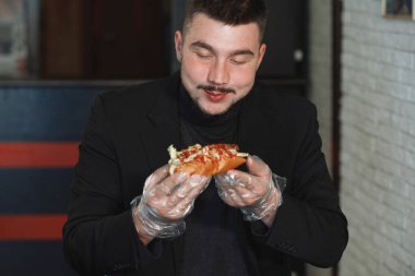 Adam hamburger yiyor.