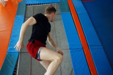 Bir trambolin üzerinde atlama genç adam.