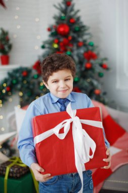 Genç çocuk Noel hediyesi kutusunu kucaklıyor..