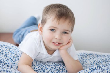 Beyaz tişörtlü ve kot pantolonlu çocuk.