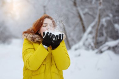 Genç, güzel, neşeli kızıl uzun saçlı kadın kışın dışarıda.