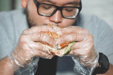 Adam hamburger yiyor.