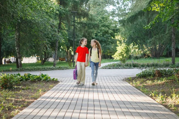 Dos adolescentes caminan por el pavimento en el parque . — Foto de Stock