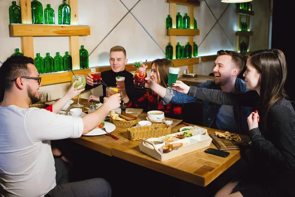 Grupo de jovens em uma mesa em um bar — Fotografia de Stock
