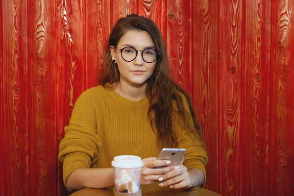 Красивая молодая женщина использует свой смартфон в кафе . — стоковое фото