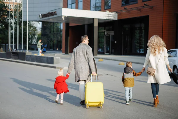 Οικογένεια με κίτρινη βαλίτσα — Φωτογραφία Αρχείου