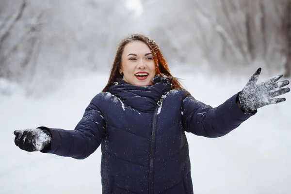 Ung, vacker kvinna i blå halsduk och jacka i en snöig skog. — Stockfoto