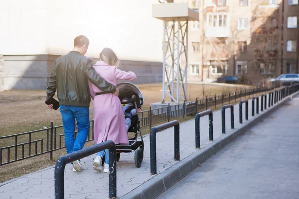 Casal jovem com uma carruagem de bebê . — Fotografia de Stock