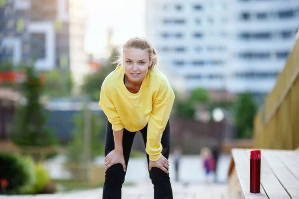 La donna sportiva in giallo si allena in un ambiente urbano . — Foto Stock