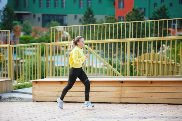 Sarı elbiseli kadın şehir ortamında eğitim görüyor.. — Stok fotoğraf