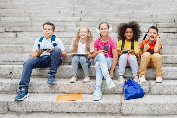 Grupp av skolbarn som sitter på skoltrappan — Stockfoto