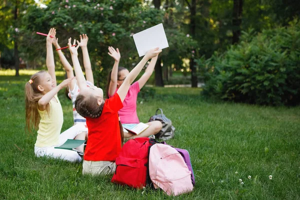 Quatre enfants assis sur l'herbe verte . — Photo