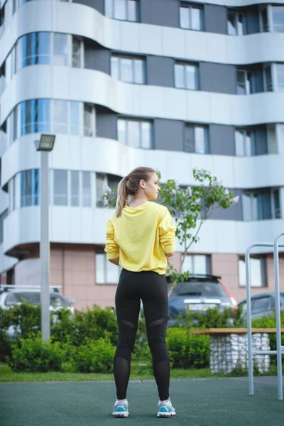 La donna sportiva in giallo si allena in un ambiente urbano . — Foto Stock