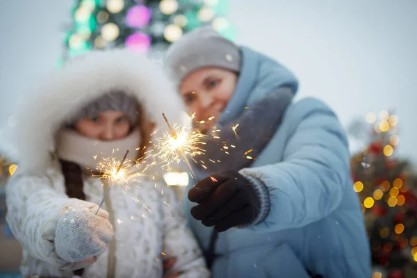 Kış giysileri içinde Noel maytaplı bir kadın ve genç kız. — Stok fotoğraf