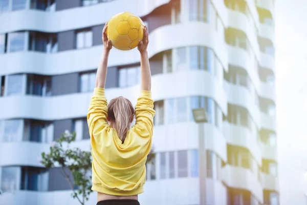 Mujer deportiva en amarillo se entrena en un entorno urbano . — Foto de Stock