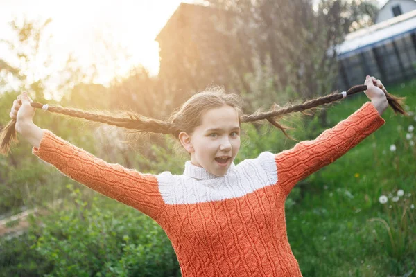 Tiener meisje ploetert met vlechten. — Stockfoto