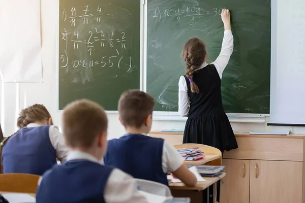 Schoolchildren in the classroom at the lesson.