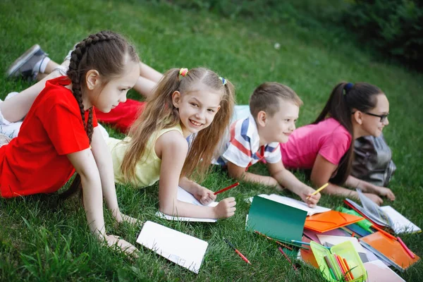 Kinderen liggend op het groene gras. — Stockfoto