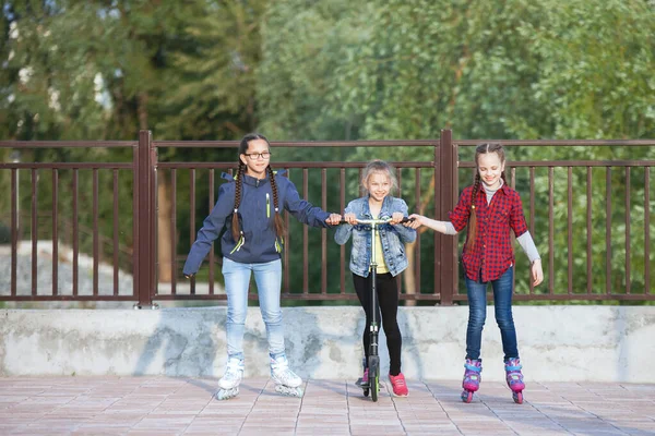 Dospívající dívky kráčející na ulici s roller a scooter — Stock fotografie