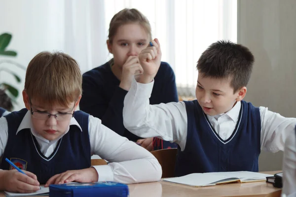 Les écoliers sont assis à leur bureau dans la salle de classe pendant l'école — Photo