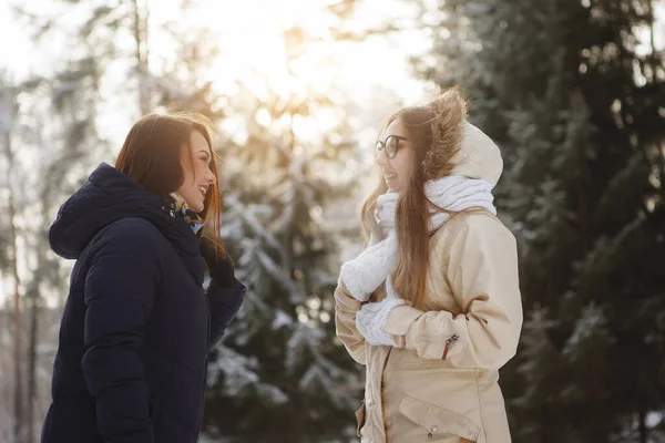 Δύο νεαρές, όμορφες γυναίκες σε ένα χιονισμένο δάσος. — Φωτογραφία Αρχείου