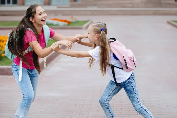 Dos amigas adolescentes se divierten y se complacen . — Foto de Stock