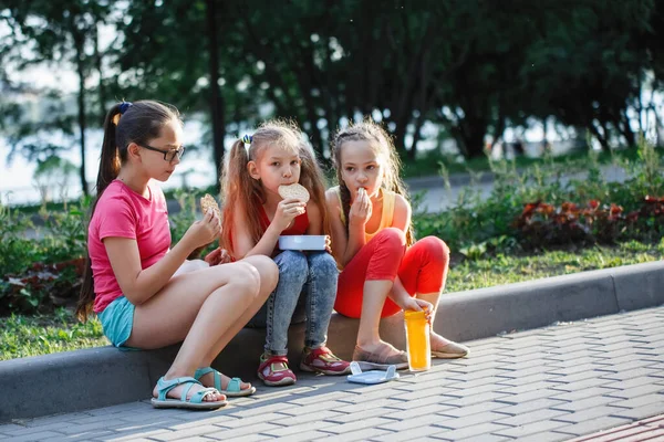 Adolescents assis sur le trottoir dans le parc de la ville . — Photo
