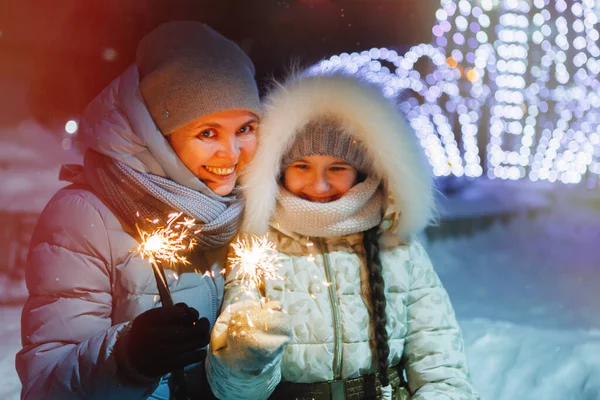 Noel havai fişekleri olan kadın ve kız. — Stok fotoğraf