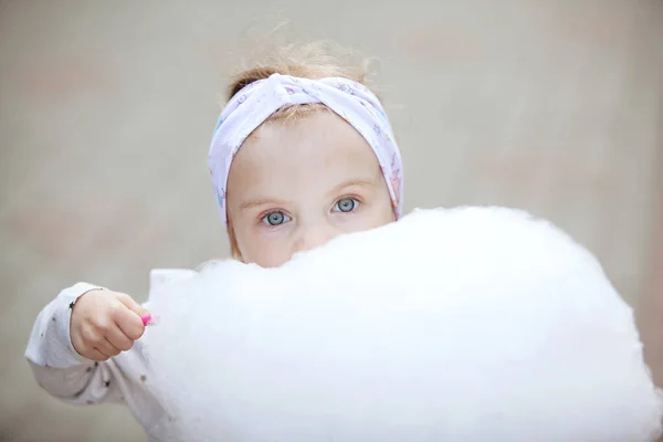Linda chica comiendo algodón de azúcar . —  Fotos de Stock