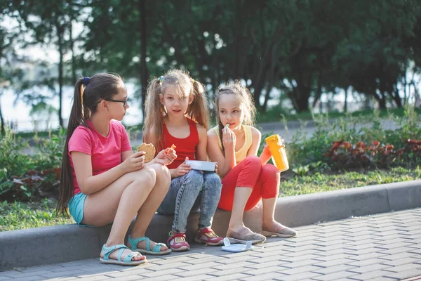 Tieners zitten op de stoep in het stadspark. — Stockfoto