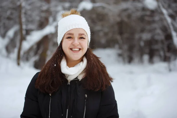 Mujer joven, guapa, alegre y de pelo largo en un bosque nevado . —  Fotos de Stock